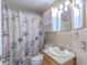 Bathroom featuring sea-themed shower curtain, wood vanity, and white storage cabinet at 1161 Hackberry Dr, Orlando, FL 32825