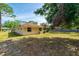 Large grassy backyard and perimeter of the house, with a tree providing shade and view to the fence line at 1221 Adams St, Longwood, FL 32750