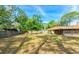 Large grassy backyard and perimeter of the house, with a tree providing shade and view to the fence line at 1221 Adams St, Longwood, FL 32750