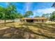 Large grassy backyard and perimeter of the house, with a tree providing shade and view to the fence line at 1221 Adams St, Longwood, FL 32750