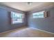 Bedroom with two windows providing natural light, wallpapered walls, and carpeted floor at 1221 Adams St, Longwood, FL 32750