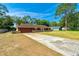 View of the house and large driveway with space for multiple vehicles, set amongst mature trees at 1221 Adams St, Longwood, FL 32750