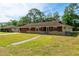 Charming single-story home with a well-maintained lawn and stone accents, providing an inviting curb appeal at 1221 Adams St, Longwood, FL 32750