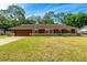 Charming single-story home with a well-maintained lawn and stone accents, providing an inviting curb appeal at 1221 Adams St, Longwood, FL 32750