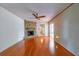 Living room featuring a stone fireplace, wood floors, and a fan at 1221 Adams St, Longwood, FL 32750
