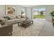 Bright living room with neutral decor, area rug, contemporary artwork and sliding glass doors to the backyard at 1221 August Sky Dr, Deltona, FL 32738