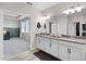This bathroom has double sinks with gray countertops and access to the bedroom and walk-in closet at 13320 Magnolia Valley Dr, Clermont, FL 34711