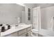 Clean bathroom featuring a white vanity and tub, a shower with relaxing shower curtain, and bright lighting at 13320 Magnolia Valley Dr, Clermont, FL 34711
