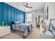 Contemporary bedroom with a blue panel wall, soft carpet, and modern furniture, providing a comfortable and stylish space at 13320 Magnolia Valley Dr, Clermont, FL 34711