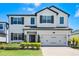 Charming two-story home features a two-car garage, dark shutters, and manicured landscaping at 13320 Magnolia Valley Dr, Clermont, FL 34711