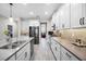 Open-concept kitchen features stainless steel appliances, stone backsplash, and a spacious center island at 13320 Magnolia Valley Dr, Clermont, FL 34711