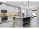 Well-lit kitchen with stainless appliances, island with barstool seating, and gray countertops at 13320 Magnolia Valley Dr, Clermont, FL 34711