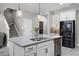 Bright kitchen island featuring stainless steel appliances, modern fixtures and white cabinets at 13320 Magnolia Valley Dr, Clermont, FL 34711