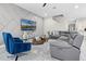 Comfortable living room with a gray sectional, blue chairs, and a modern accent wall at 13320 Magnolia Valley Dr, Clermont, FL 34711
