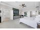 This spacious main bedroom features a tray ceiling, a ceiling fan, and ensuite bathroom and walk in closet entrances at 13320 Magnolia Valley Dr, Clermont, FL 34711