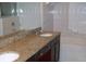 Bathroom featuring dual sinks, granite countertops, and a bathtub with tile surround at 143 Villa Di Este Ter # 205, Lake Mary, FL 32746