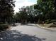 Gated entrance to a residential community with mature trees lining the road at 143 Villa Di Este Ter # 205, Lake Mary, FL 32746