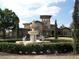 Grand home features a large decorative fountain, well-manicured landscaping, and a unique architectural style at 143 Villa Di Este Ter # 205, Lake Mary, FL 32746