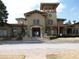Building exterior showcasing covered walkways, stone accents, and meticulously landscaped grounds at 143 Villa Di Este Ter # 205, Lake Mary, FL 32746