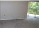 A spacious living room featuring neutral carpeting, outlets, and glass door to the outside at 143 Villa Di Este Ter # 205, Lake Mary, FL 32746