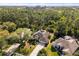 Aerial view of a home surrounded by lush greenery with a long driveway and well maintained landscaping at 14378 Stamford Cir, Orlando, FL 32826