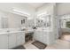 Bright bathroom featuring a large mirror, double vanity, tiled floors and a walk-in shower at 14378 Stamford Cir, Orlando, FL 32826