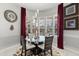 Cozy dining area with a round glass table, elegant chandelier, and large windows at 14378 Stamford Cir, Orlando, FL 32826