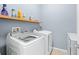 Bright laundry room with washer, dryer, and shelving for storage at 1540 Softshell St, St Cloud, FL 34771