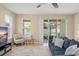 Cozy living room with a comfortable blue sofa, neutral walls, and sliding glass doors to the patio at 1540 Softshell St, St Cloud, FL 34771