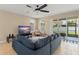 Comfortable living room with a plush sectional sofa, a modern ceiling fan, and sliding glass doors at 1540 Softshell St, St Cloud, FL 34771