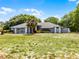 Desirable one-story home showcasing a bright red front door, mature trees, and large front lawn at 1689 Saboff Way, Chuluota, FL 32766