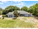 Inviting one-story home showcasing a bright red front door, mature trees, and large front lawn at 1689 Saboff Way, Chuluota, FL 32766