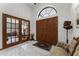 Bright foyer with double wood doors, transom window, and tile flooring at 1689 Saboff Way, Chuluota, FL 32766