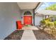 Inviting front entrance featuring a bright red door, bench, and manicured landscaping at 1689 Saboff Way, Chuluota, FL 32766