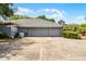 Side view of a spacious two-car garage with large driveway and manicured landscaping at 1689 Saboff Way, Chuluota, FL 32766