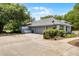 Attached two-car garage with side access, paved driveway, and mature trees at 1689 Saboff Way, Chuluota, FL 32766