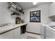 Laundry room with white cabinets, utility sink, and shelving for storage at 1689 Saboff Way, Chuluota, FL 32766
