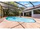 Screened in pool has a small palm tree on the deck and steps leading into the water at 1689 Saboff Way, Chuluota, FL 32766