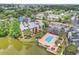 Aerial view of the property featuring a community pool, a lake, and lush greenery at 1908 Lake Atriums Cir # 3, Orlando, FL 32839