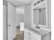 Clean bathroom featuring a large mirror, single sink vanity and an open doorway with views to the next room at 1908 Lake Atriums Cir # 3, Orlando, FL 32839