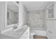 Well-lit bathroom featuring a modern vanity, mirror, toilet, and bathtub with elegant marble-like tile at 1908 Lake Atriums Cir # 3, Orlando, FL 32839