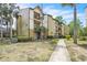 Exterior shot of a multi-story condominium complex with palm trees and green lawns at 1908 Lake Atriums Cir # 3, Orlando, FL 32839