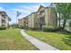View of a well-maintained condominium building with lush landscaping and a sidewalk leading to the entrance at 1908 Lake Atriums Cir # 3, Orlando, FL 32839