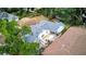 Aerial view of a house with a blue roof and a spacious backyard with a picnic table and green trees at 2114 Gerda Ter, Orlando, FL 32804
