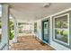 A covered front porch with wood floors and a welcome mat and white rails adds charm to the home's entrance at 2114 Gerda Ter, Orlando, FL 32804