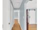 Hallway with hardwood floors, blue walls, and a white sliding barn door at 2114 Gerda Ter, Orlando, FL 32804