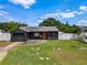 Landscaped home with a dark exterior, fenced yard, and charming curb appeal at 2121 Vivada St, Orlando, FL 32803
