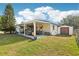 Backyard with a covered patio and storage shed, surrounded by a lush lawn, providing a private outdoor retreat at 2314 Falkner Rd, Orlando, FL 32810