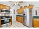 Bright kitchen featuring stainless steel appliances, oak cabinetry, and an adjacent dining area at 2314 Falkner Rd, Orlando, FL 32810