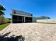 A backyard featuring brick pavers leads to a covered lanai and a meticulously maintained privacy fence at 2648 Needlepoint St, Kissimmee, FL 34741